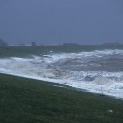 Sturmflut am Deich - Blick von der Deichkrone auf die heranrollenden Wellen